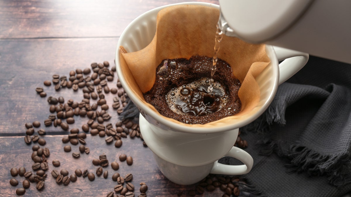 Hot water is poured into a coffee filter in a mug.