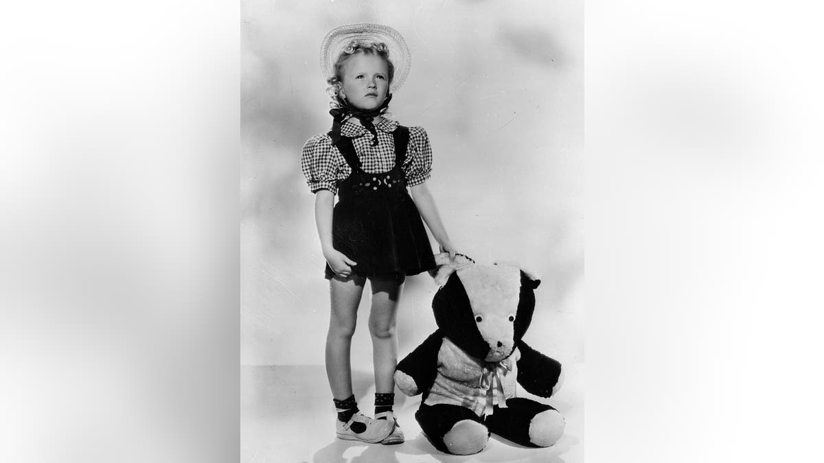 Karolyn Grimes in overalls next to a bear posing in costume