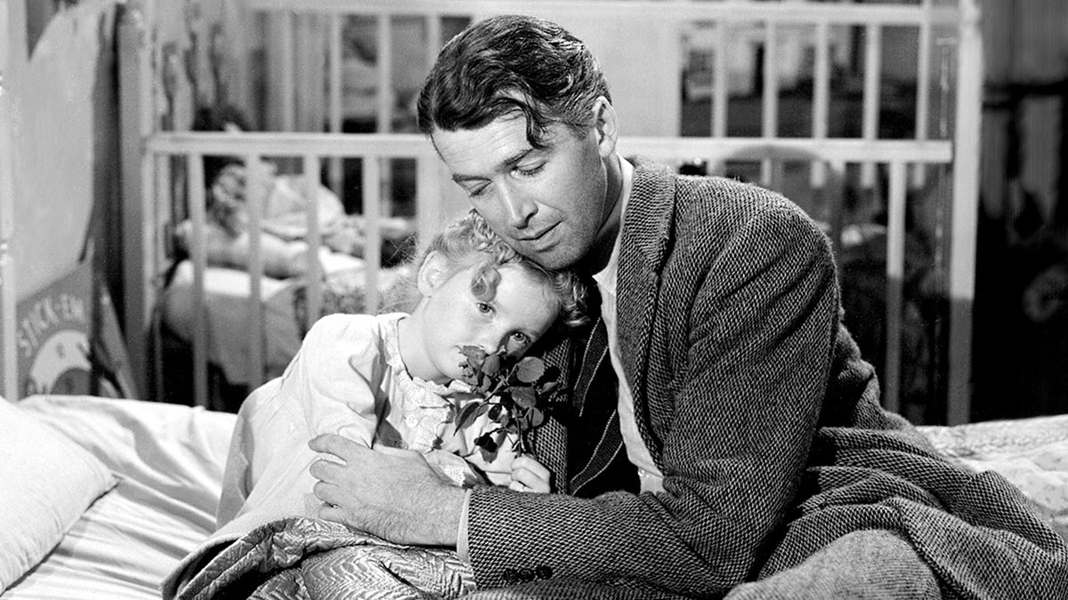 James Stewart embracing Karolyn Grimes.