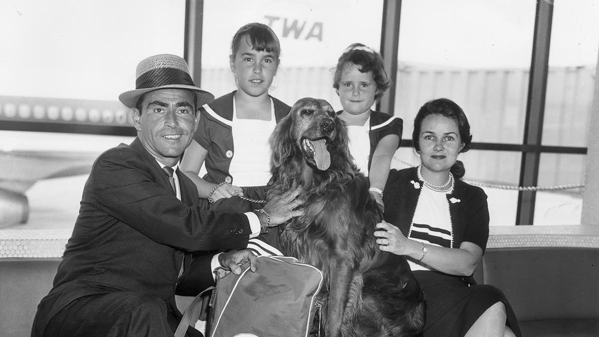 Rod Serling in a suit with his family at the airport.