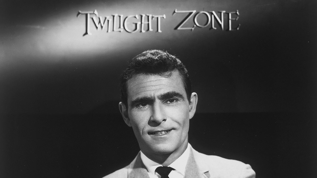 A close-up of Rod Serling in a suit with the Twilight Zone logo over his head.