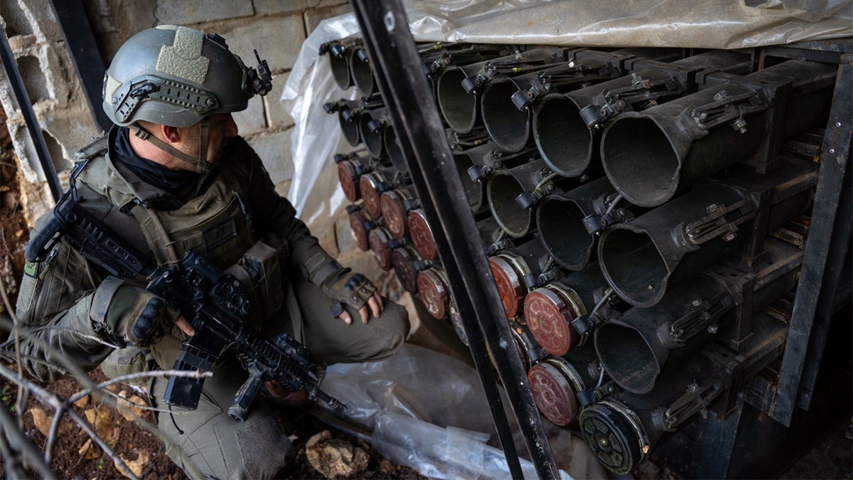 IDF soldier poses next to weapons cache