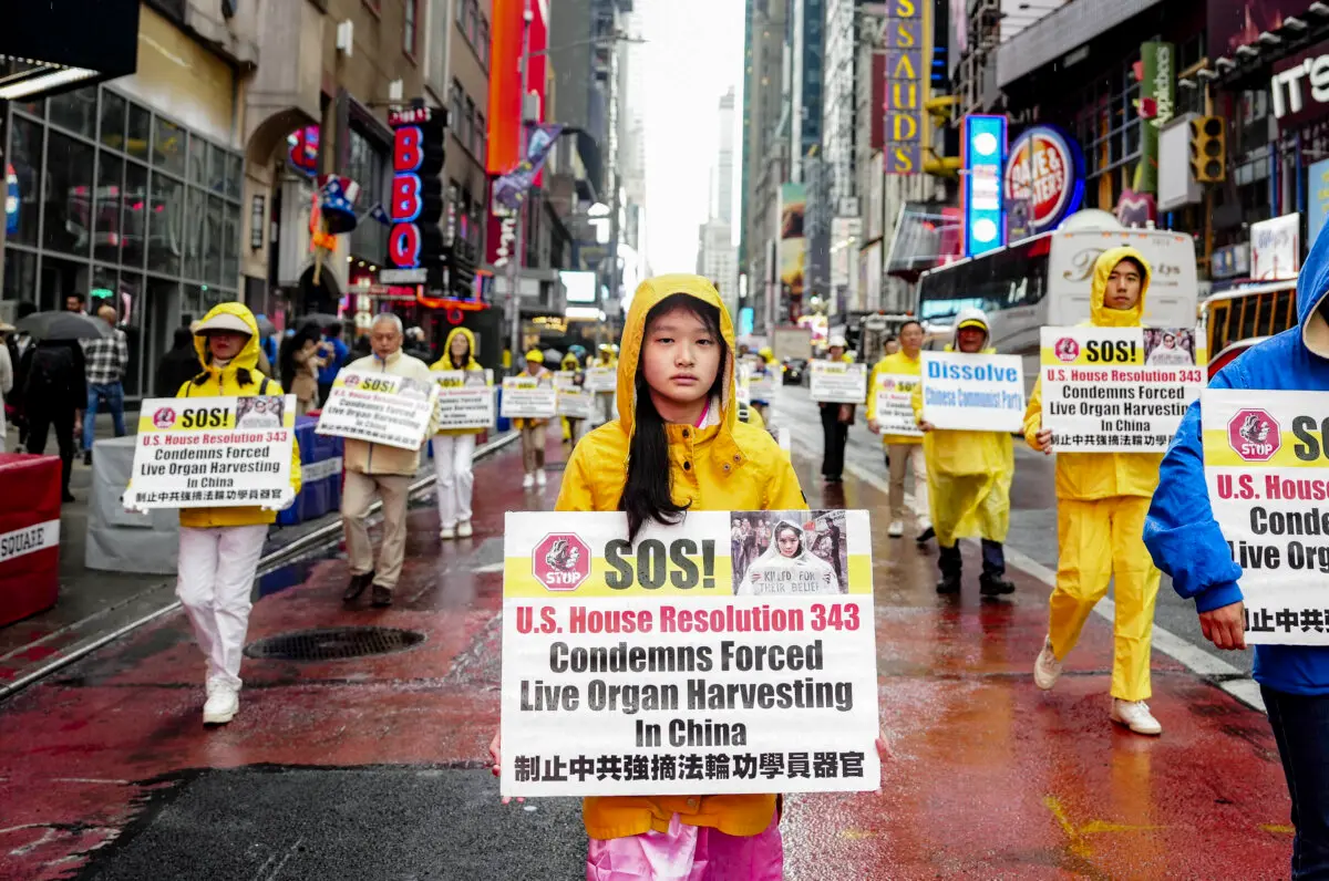 Falun Gong practitioners take part in a parade in New York City on May 10, 2024, to celebrate World Falun Dafa Day while calling for an end to the persecution of the spiritual practice in China. The placards they hold raise awareness of the Chinese regime's state-sanctioned forced organ harvesting, which primarily targets Falun Gong practitioners. (Samira Bouaou/The Epoch Times)