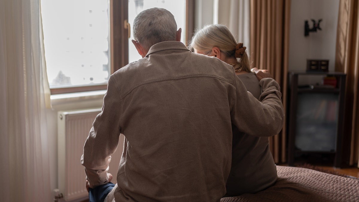 Senior Couple Sitting On The Bed And Looking Away