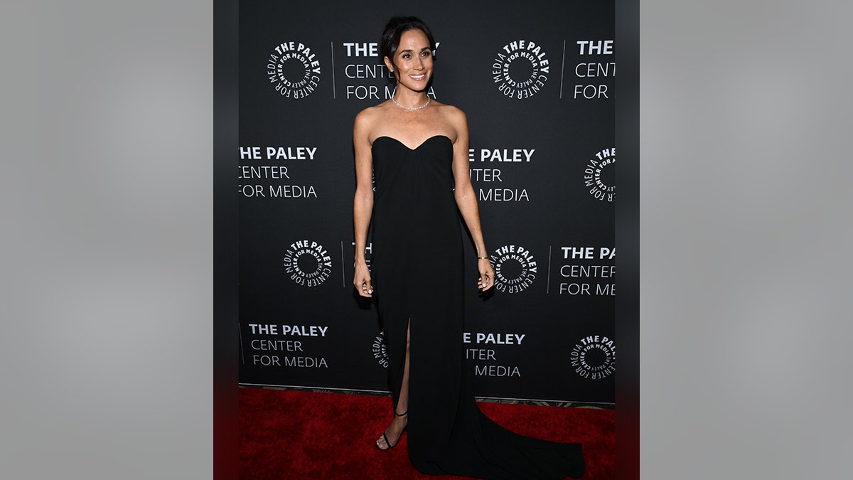 Meghan Markle wearing a sleeveless glamorous black gown.