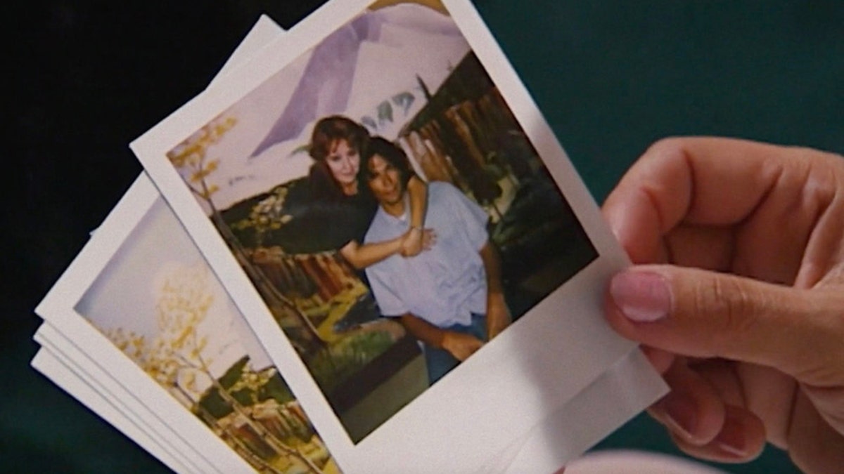 Someone holding a photo of Doreen Lioy embracing Richard Ramirez