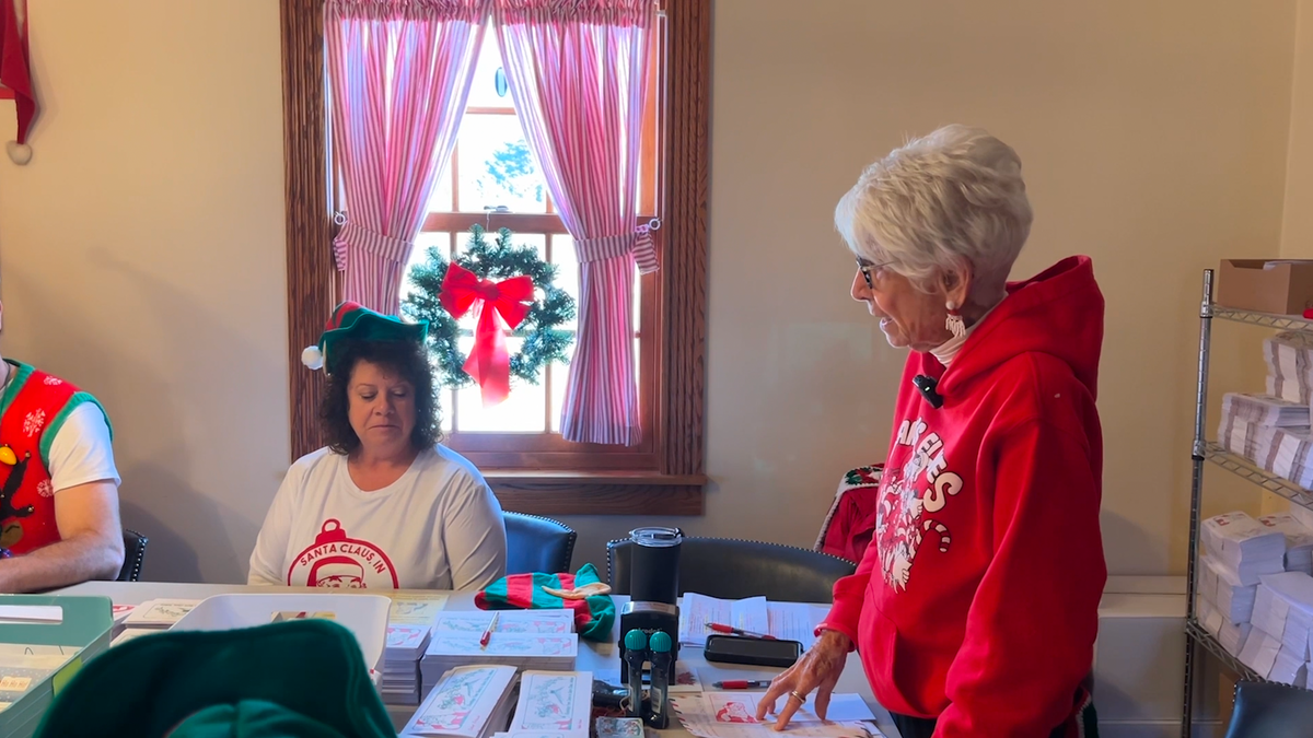 Chief Elf Pat Koch instructs volunteers how to reply to kid's letters to Santa