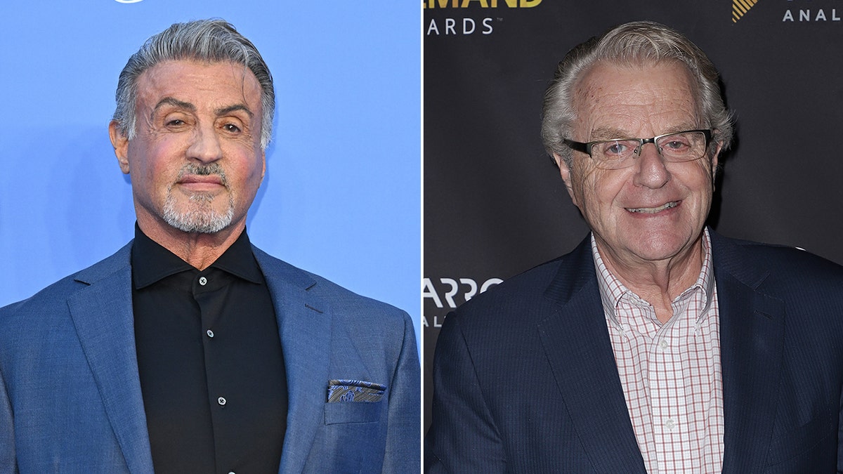 Sylvester Stallone looks stoic on the carpet wearing a black shirt and sky blue jacket split Jerry Springer smiles wearing a checkered shirt and navy suit