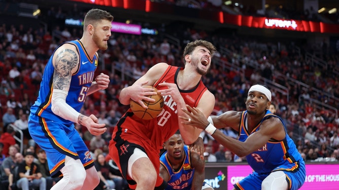 Houston Rockets C Alperen Sengun tries to secure the ball from Oklahoma City Thunder C Isaiah Hartenstein and PG Shai Gilgeous-Alexander at Toyota Center. (Troy Taormina-Imagn Images)