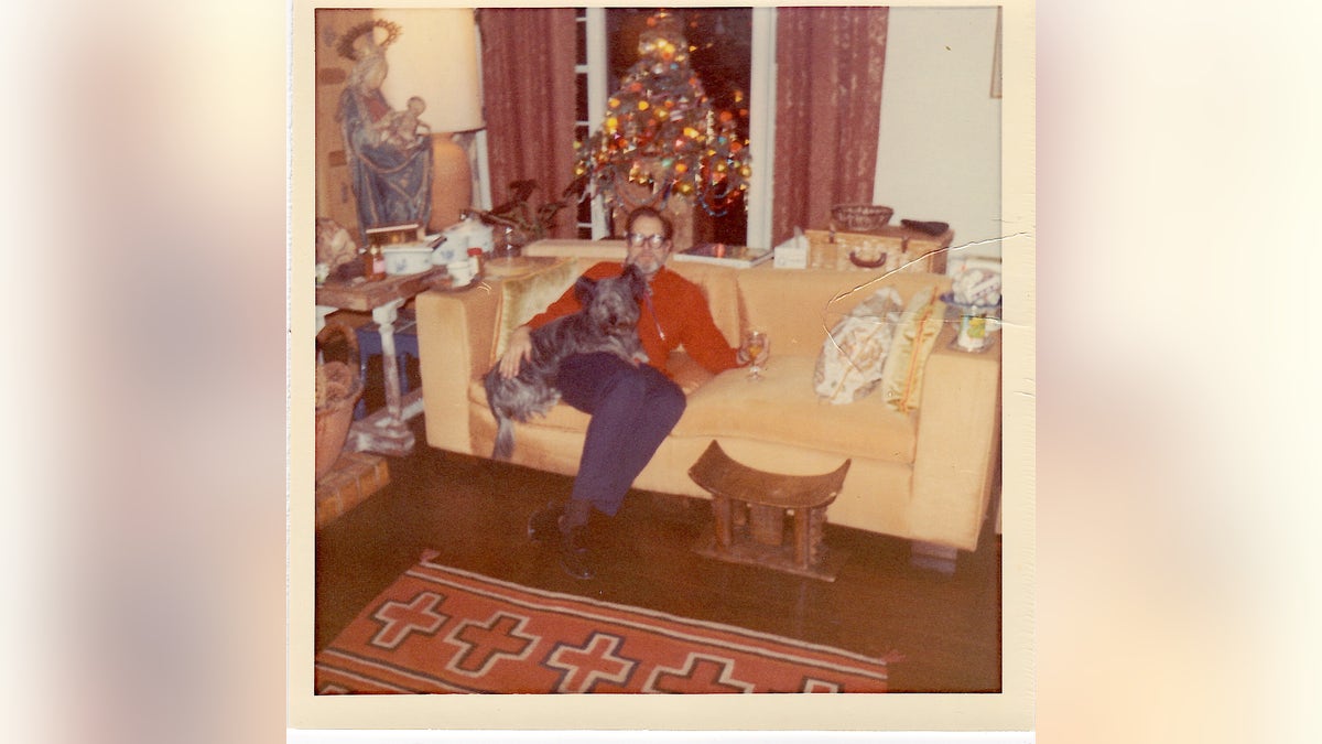 Vincent Price sitting in front of the Christmas tree