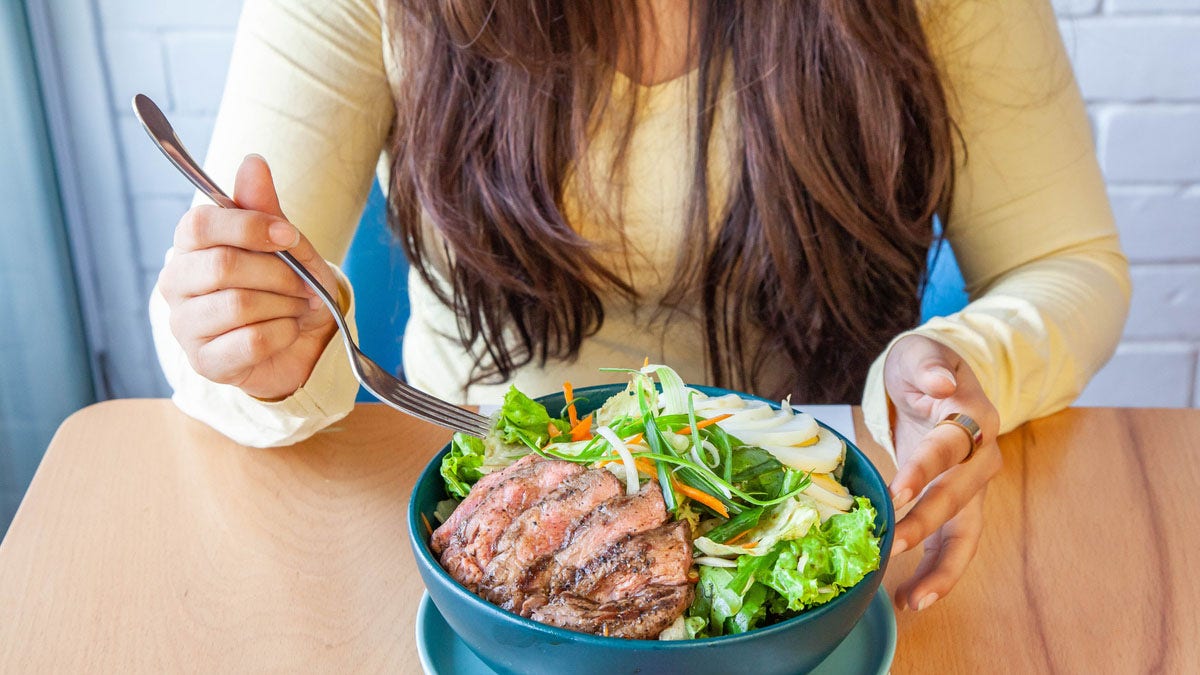 Woman eating steak