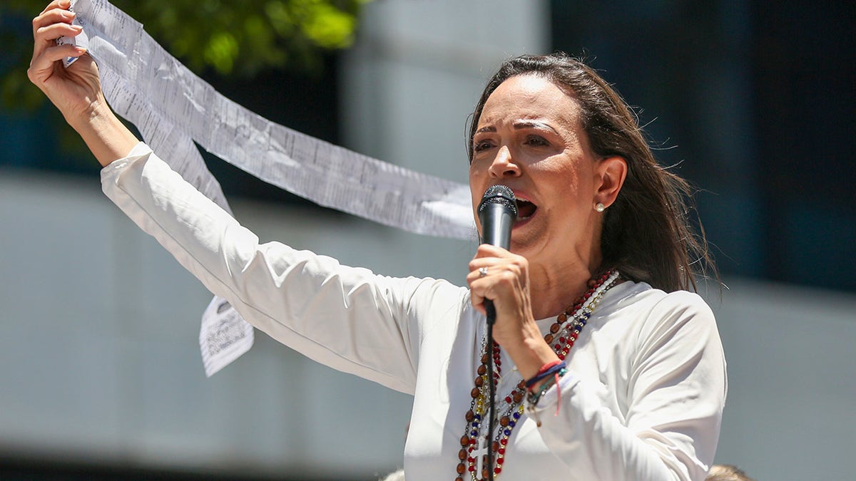 Opposition leader Maria Corina Machado displays vote tally sheets during a protest against the re-election of President Nicolás Maduro one month after the disputed presidential vote which she says the opposition won by a landslide, in Caracas, Venezuela, on Wednesday, Aug. 28, 2024.