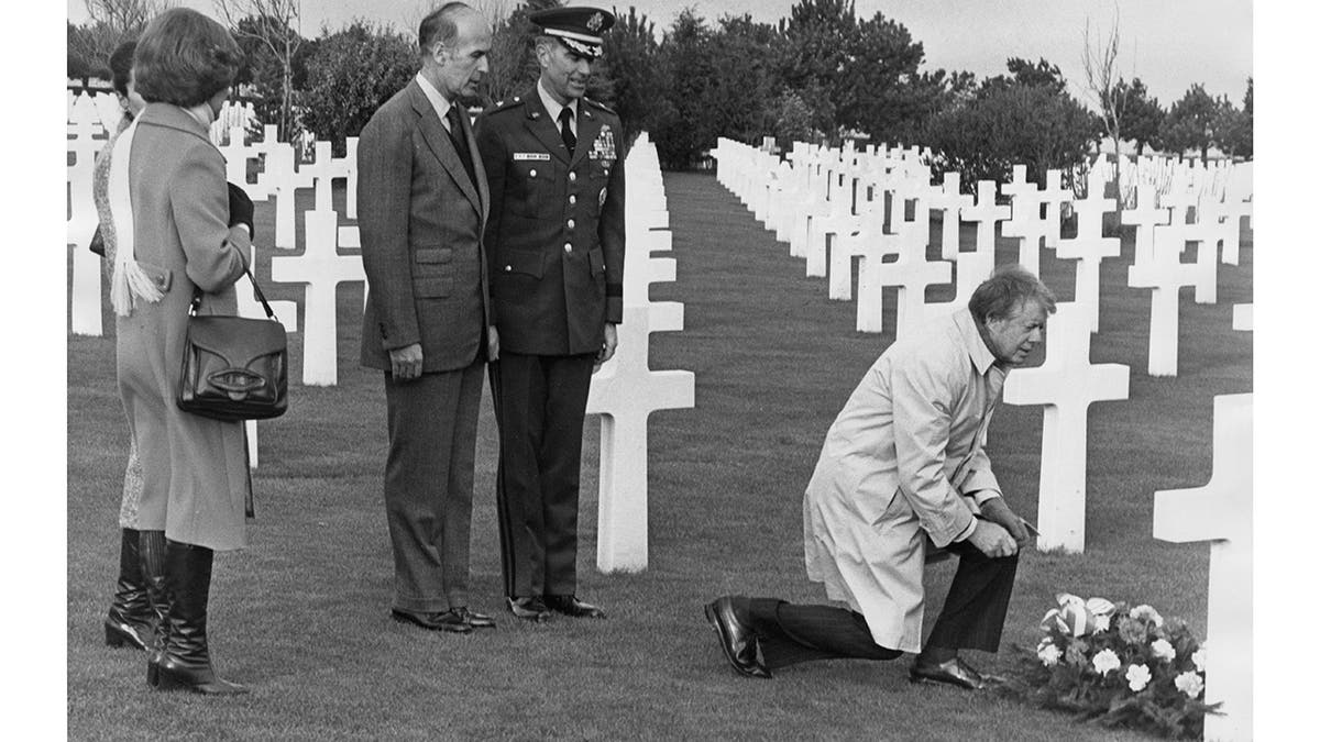 President Jimmy Carter places a wreath on the grave of Brigadier General Theodore Roosevelt Jr., son of former President Theodore Roosevelt, in Normandy, France, watched by his wife Rosalynn and French President Valéry Giscard d'Estaing, January 6, 1978.