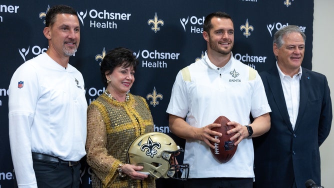 New Orleans Saints head coach Dennis Allen, owner Gayle Benson, QB Derek Carr, and GM Mickey Loomis at a press conference after signing Carr in 2024. (Stephen Lew-USA TODAY Sports)