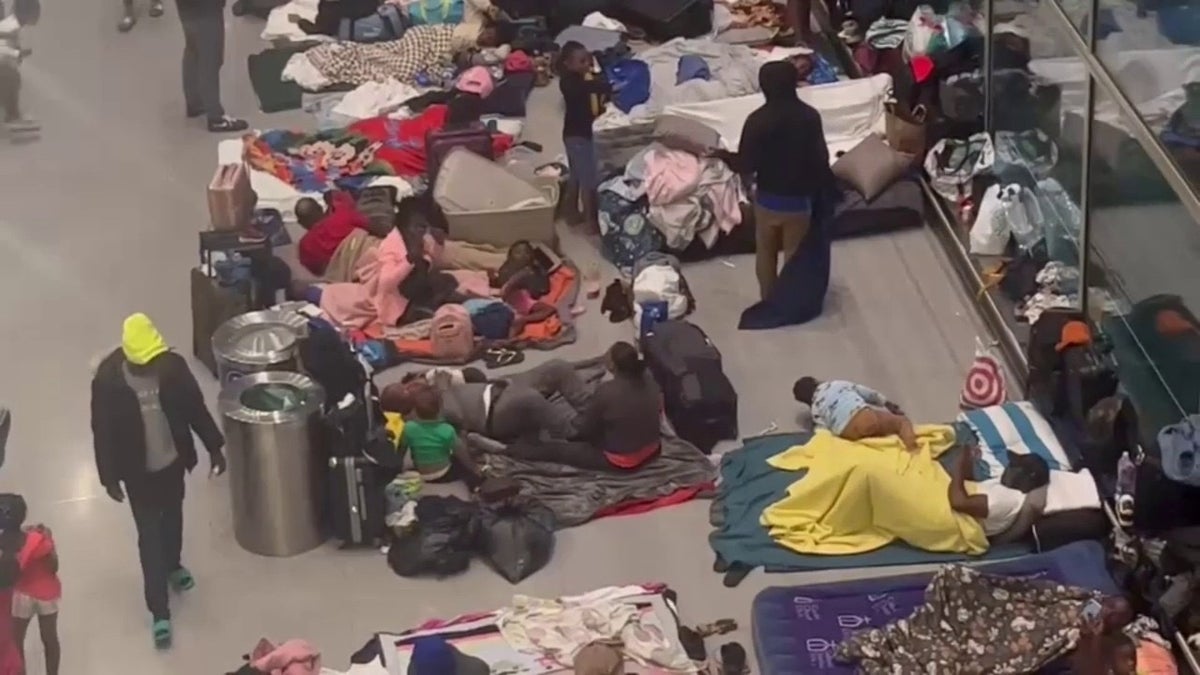 Migrants sleep at Boston airport.