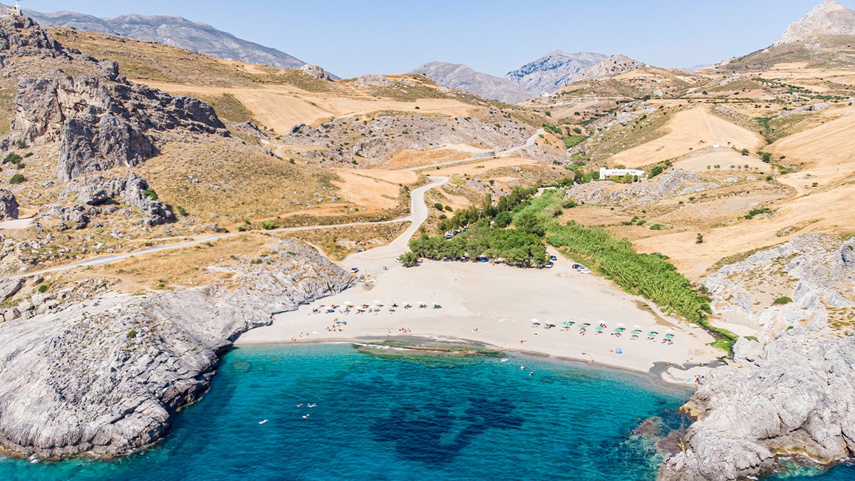 Panoramic aerial view from a drone of Ammoudi beach in Rethymno in Crete Island with the Cretan mountains in the background. Clara Thomann, 33, plunged to her death while hiking near near Preveli Monastery in the region.