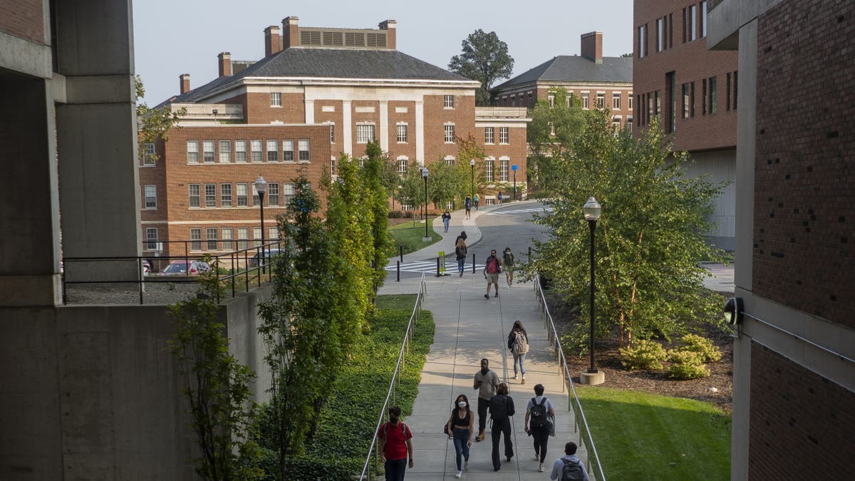 Students walk on University of Rochester campus by the business school