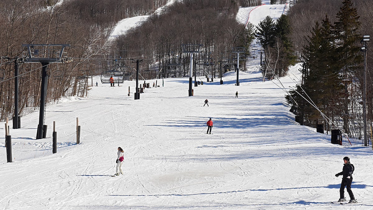 Skiers make their way down the slope at Jiminy Peak Mountain Resort