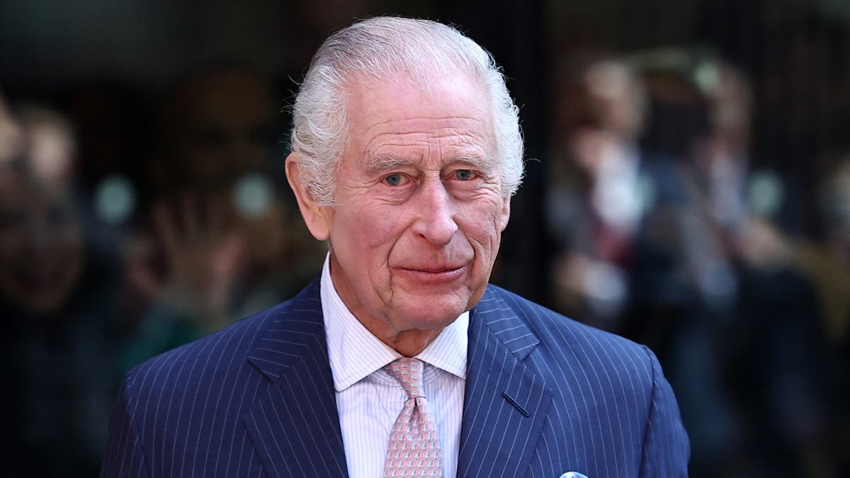 A close-up of King Charles in a striped blue suit