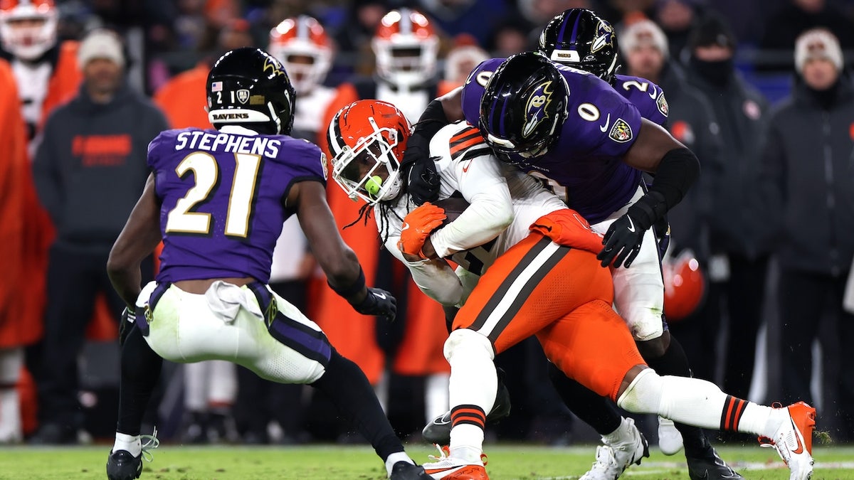 D'Onta Foreman (27) of the Cleveland Browns is tackled by Roquan Smith (0) of the Baltimore Ravens during the second quarter at M&T Bank Stadium Jan. 4, 2025, in Baltimore. 