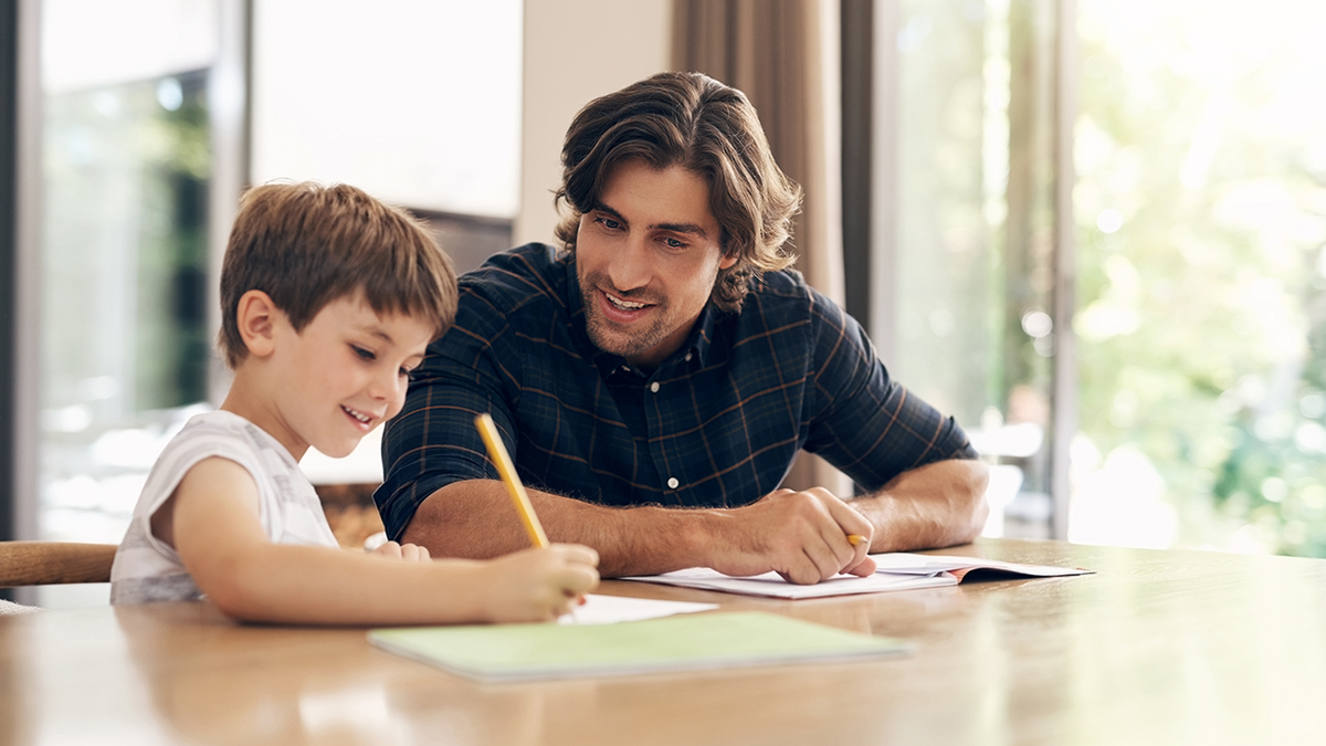 Dad helping son with handwriting