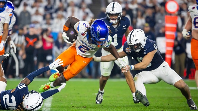 Boise State Broncos RB Ashton Jeanty is tackled by the Penn State Nittany Lions during the Fiesta Bowl in the 2024-25 College Football Playoff quarterfinal at State Farm Stadium in Glendale, Arizona. (Photo credit: Mark J. Rebilas-Imagn Images). 