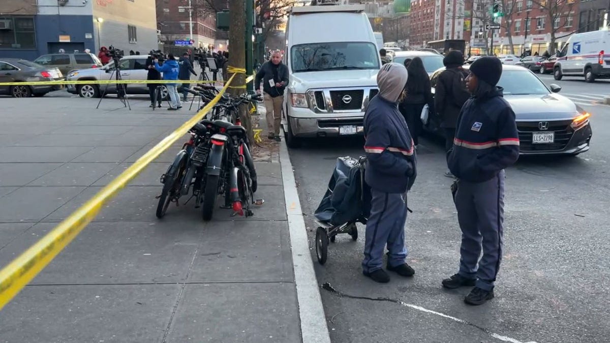 Two postal workers outside a Harlem deli