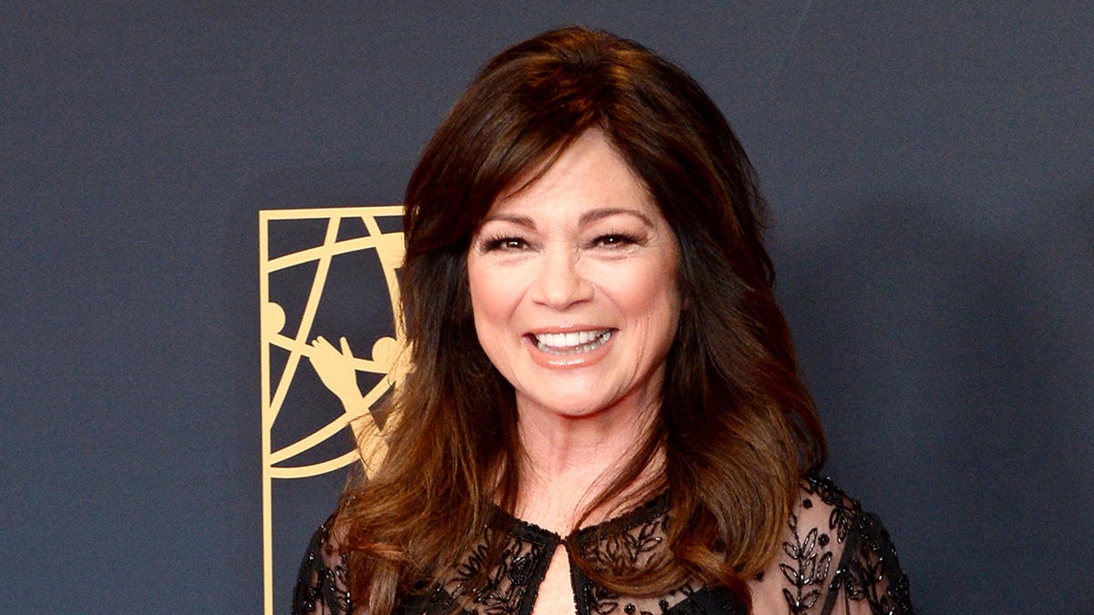 Actress Valerie Bertinelli smiles on red carpet wearing sheer blouse